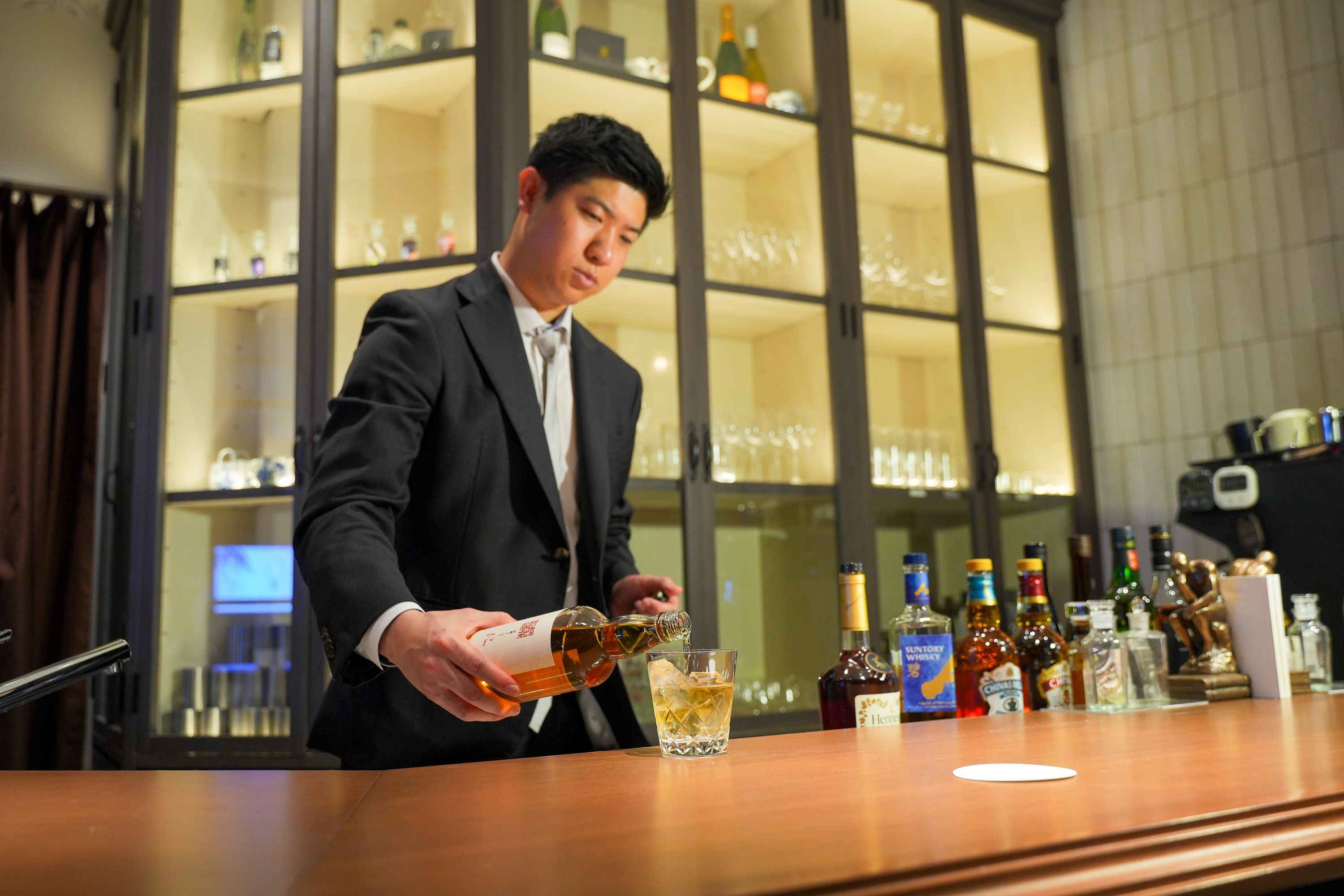 スタッフがウイスキーを注ぐ
